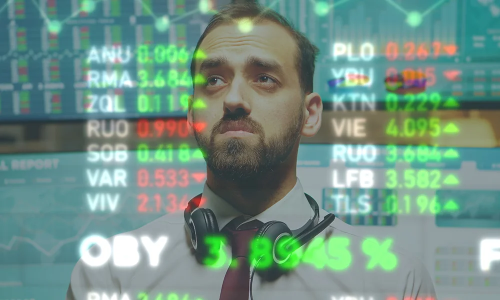 Finance professional standing before market data screens representing Asian capital-market resilience